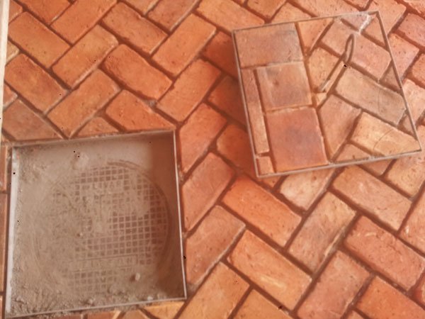 Izdelava pokrova za vodovodni jašek. Okvir se je zavaril iz nerjavnega jekla. Opeka in bobrovec se stikata prav na pokrovu.