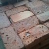 Stara opeka razrezana na pol in preščetkana z žičnato krtačo. Opeka je pripravljena za oblaganje tal.